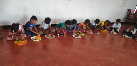 Grade 1 Nature's Palette 3_result Creative artwork by 1st standard students at one of the best schools in Salem, depicting a lotus carved from an onion and curry leaves on a ceramic plate.