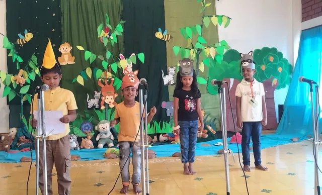 oung students practicing with microphones at Vidhya Peetham i-School, preparing for their roles in the White Elephant Theatre skits.