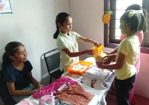 Excited group of third-grade students role-playing as shop owners and customers, showcasing their mastery of multiplication in a statement problem activity at a renowned Salem school.