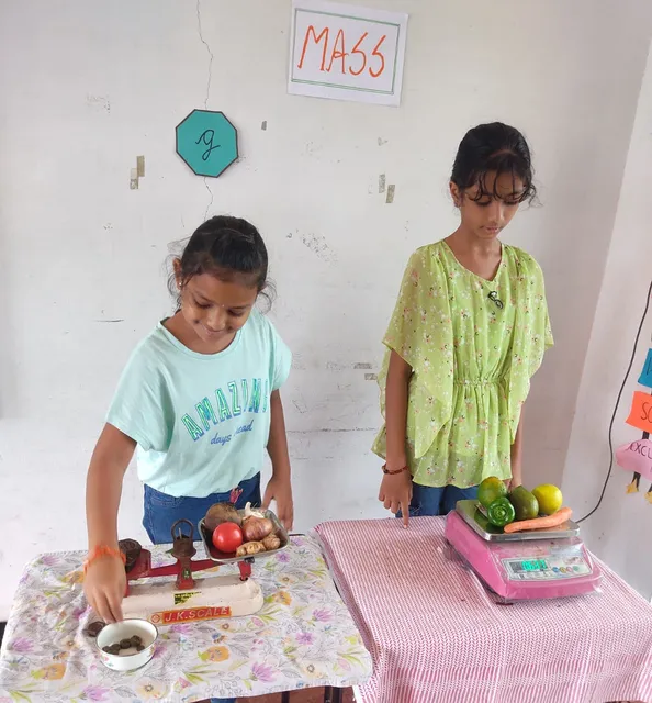 Grade 4 science activity 6_result Grade 4 students learning to measure mass with traditional scales by weighing fruits and vegetables in a science class.