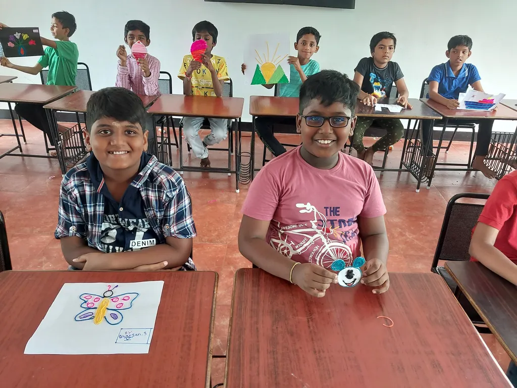 A group of enthusiastic fifth graders proudly displaying their yarn art pieces, including suns and mountains, in a classroom at a top CBSE school in Salem.