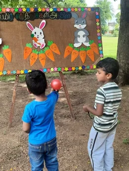 Colorful chart cutouts of rabbits and carrots used for Tamil alphabet activities at a prominent school in Salem.