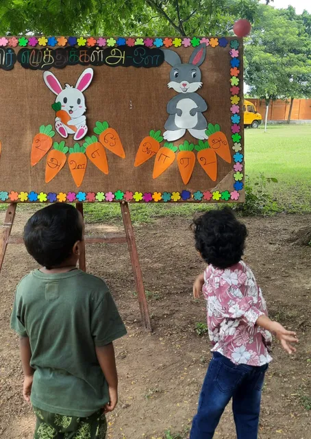 Interactive Tamil 'உயிர் எழுத்து' recognition activity with playful ball popping at a leading Salem school.