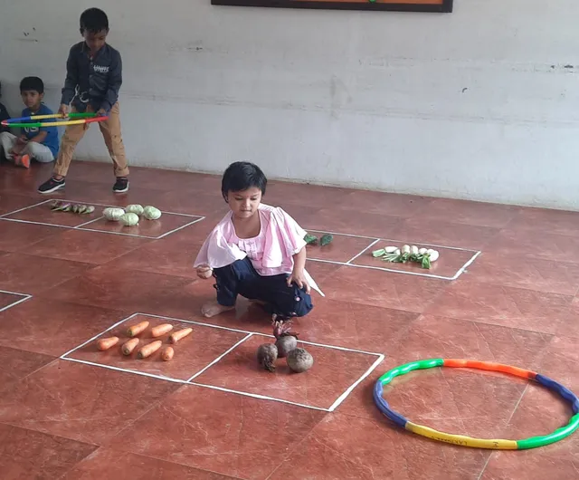 Kindergarten math activities at a CBSE school in Salem learning about number groups with a vegetable counting activity.