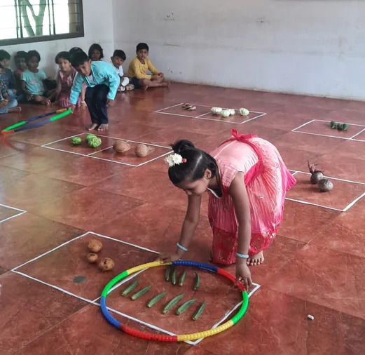 Salem's best school's UKG students use hula hoops to identify bigger counts of vegetables in a fun learning session.