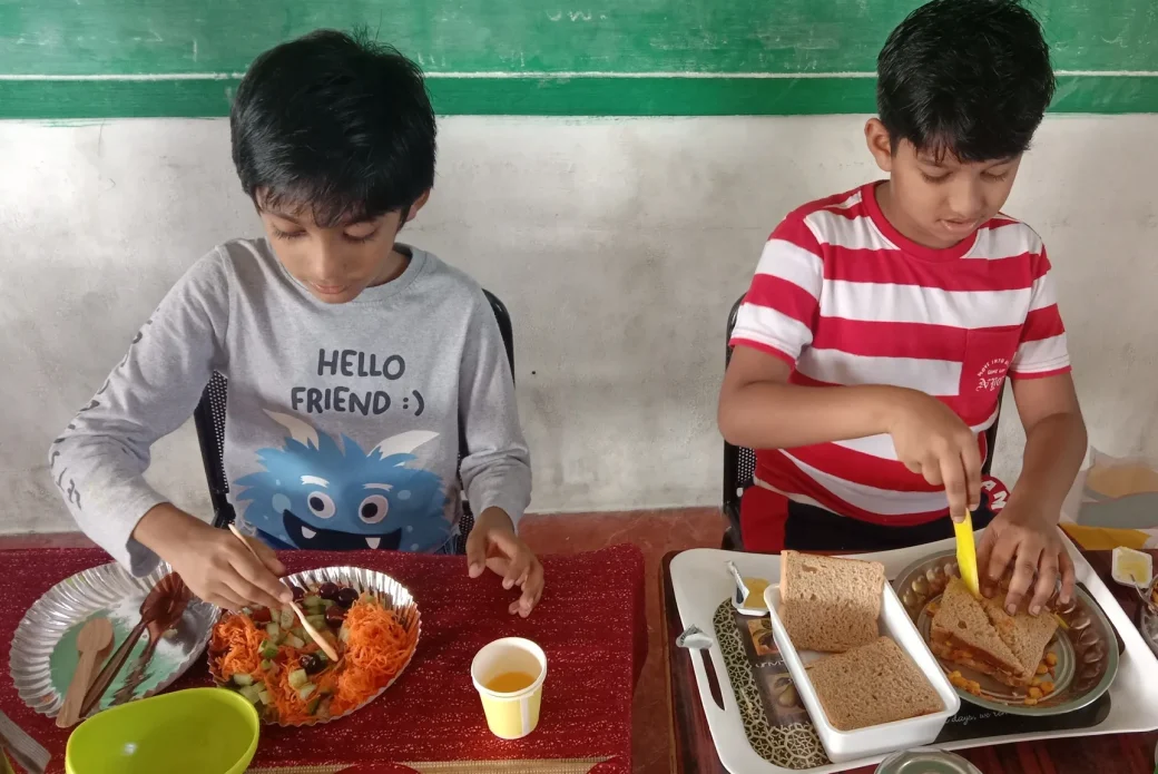 Third-grade students at a CBSE school in Salem engaging in a flameless cooking activity, mixing ingredients with a focus on creating healthy raw food recipes.