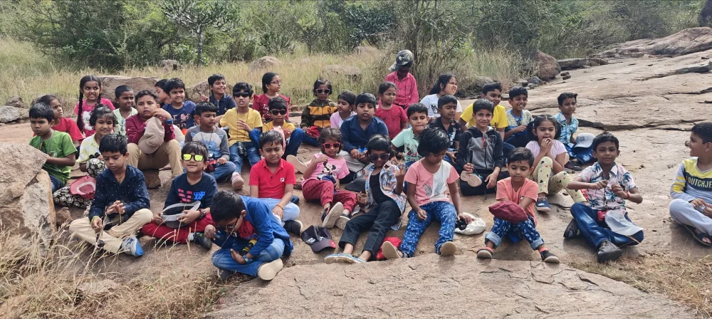 Young learners from one of the best schools in Salem taking a break on their nature walk.
