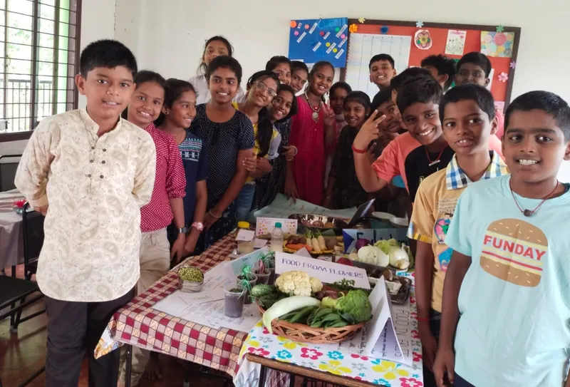 Two cheerful students from Vidhya Peetham i-School in Salem proudly presenting their food from plants and animals