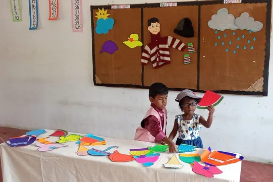 LKG children at Vidhya Peetham i-School, one of the top CBSE schools in Salem, demonstrate the use of seasonal clothing by dressing up for their kindergarten seasons activity.