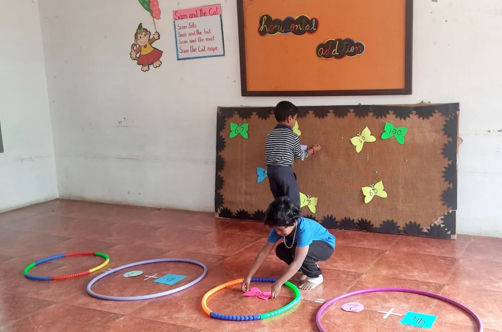 UKG addition activity - students engaging in colorful hula hoops and paper butterflies at Vidhya Peetham i-School, a top CBSE school in Salem.