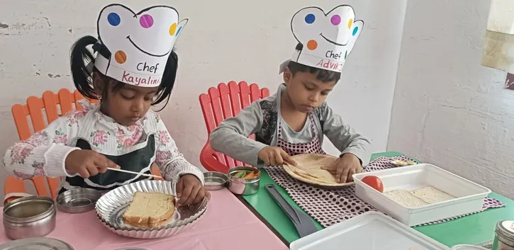 A young chef at Vidhya Peetham i-School spreading butter on bread slices, getting ready to make a healthy vegetable sandwich. ??