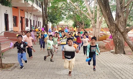 Energetic 2nd grade students from the best CBSE school in Salem running with their colorful pinwheels.