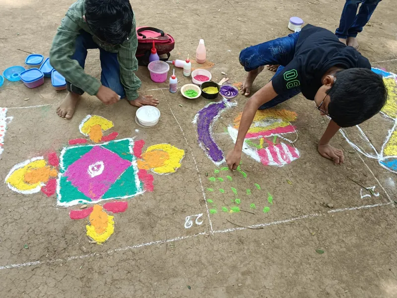 Children focused on perfecting Rangoli designs with a blend of colors and shapes, illustrating the artistic spirit at one of the best schools in Salem.