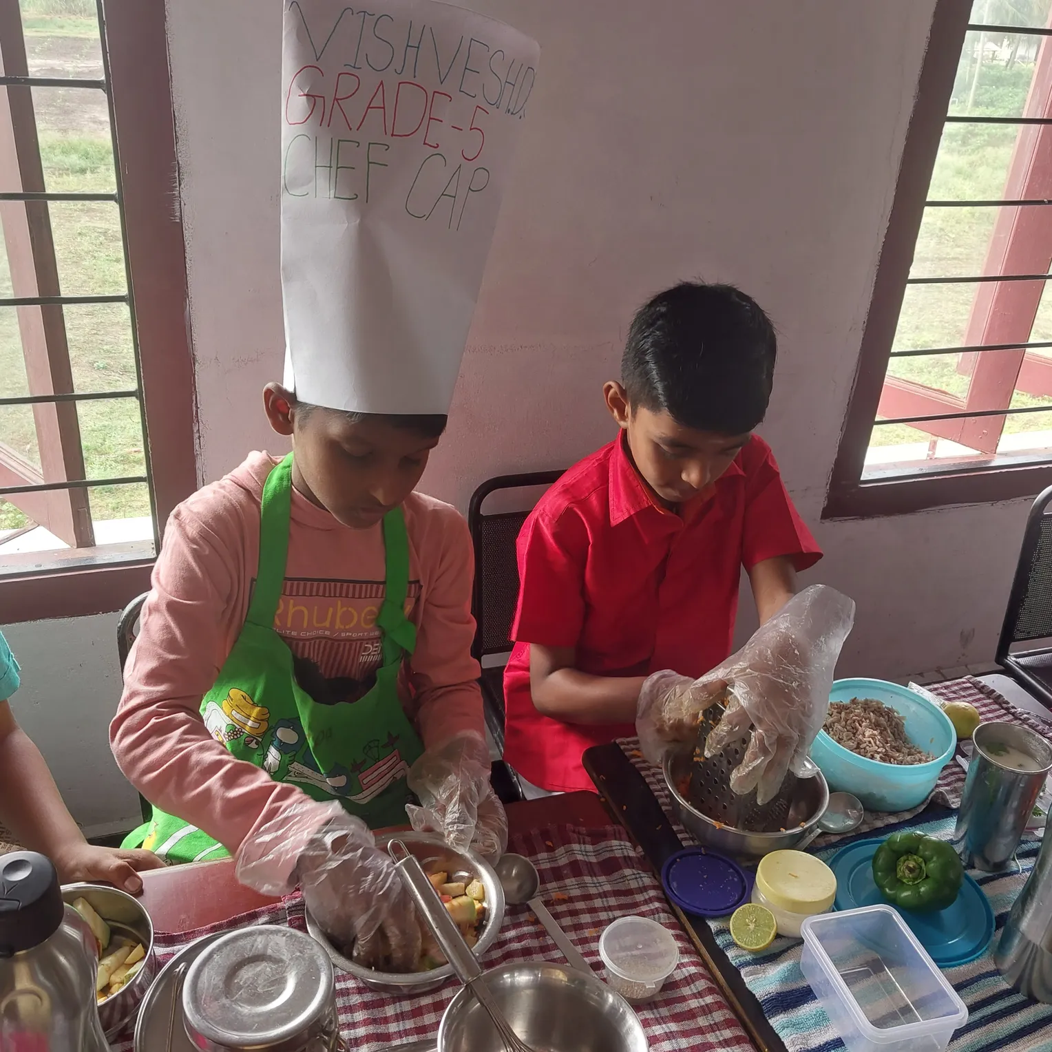 A team of young chefs at Vidhya Peetham i-School proudly wearing chef hats while preparing flameless dishes.