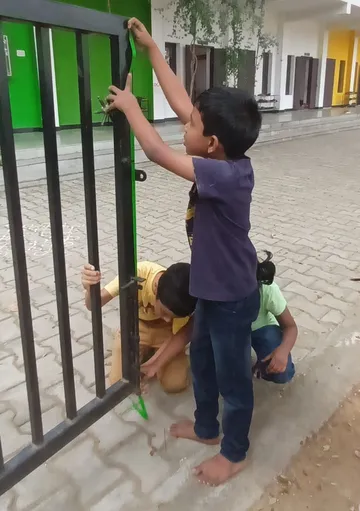 Engaged 2nd graders at Vidhya Peetham i-School measuring gate height as part of their hands-on math activity.
