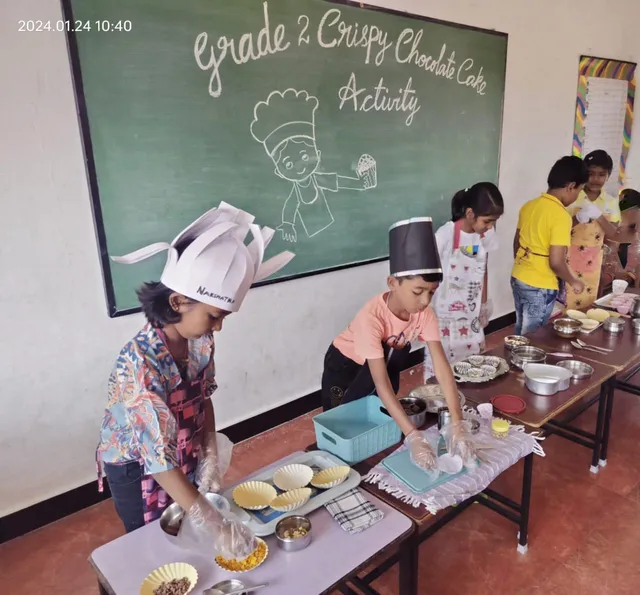 Students in a classroom at the best CBSE school in Salem, engaged in a hands-on chocolate cake making science activity.