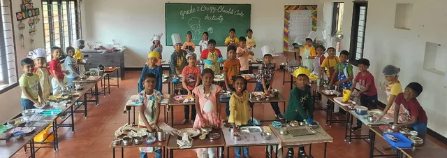 A group of Grade 2 students proudly holding their homemade Crispy Chocolate Cakes at Vidhya Peetham i-School.