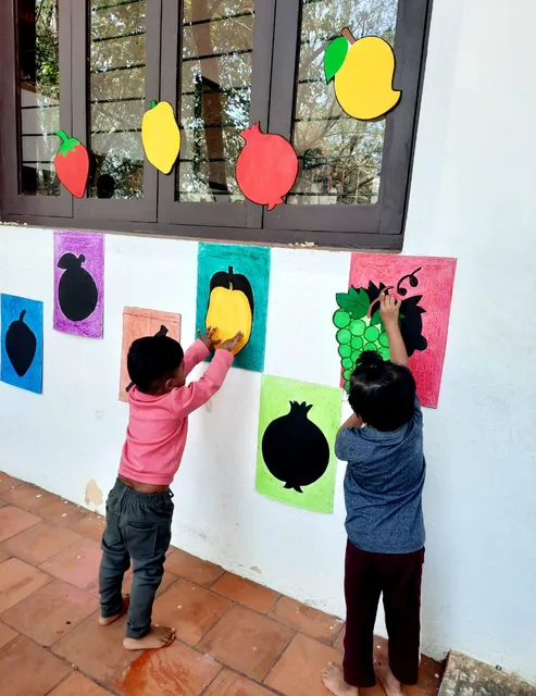 PreKG students at Vidhya Peetham i-School engaging in a fruits identification activity with colorful fruit-shaped stencils.