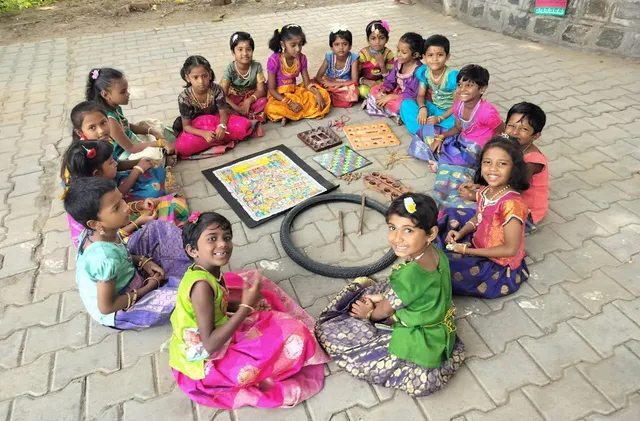 Children sitting in a circle playing a traditional Tamil game.