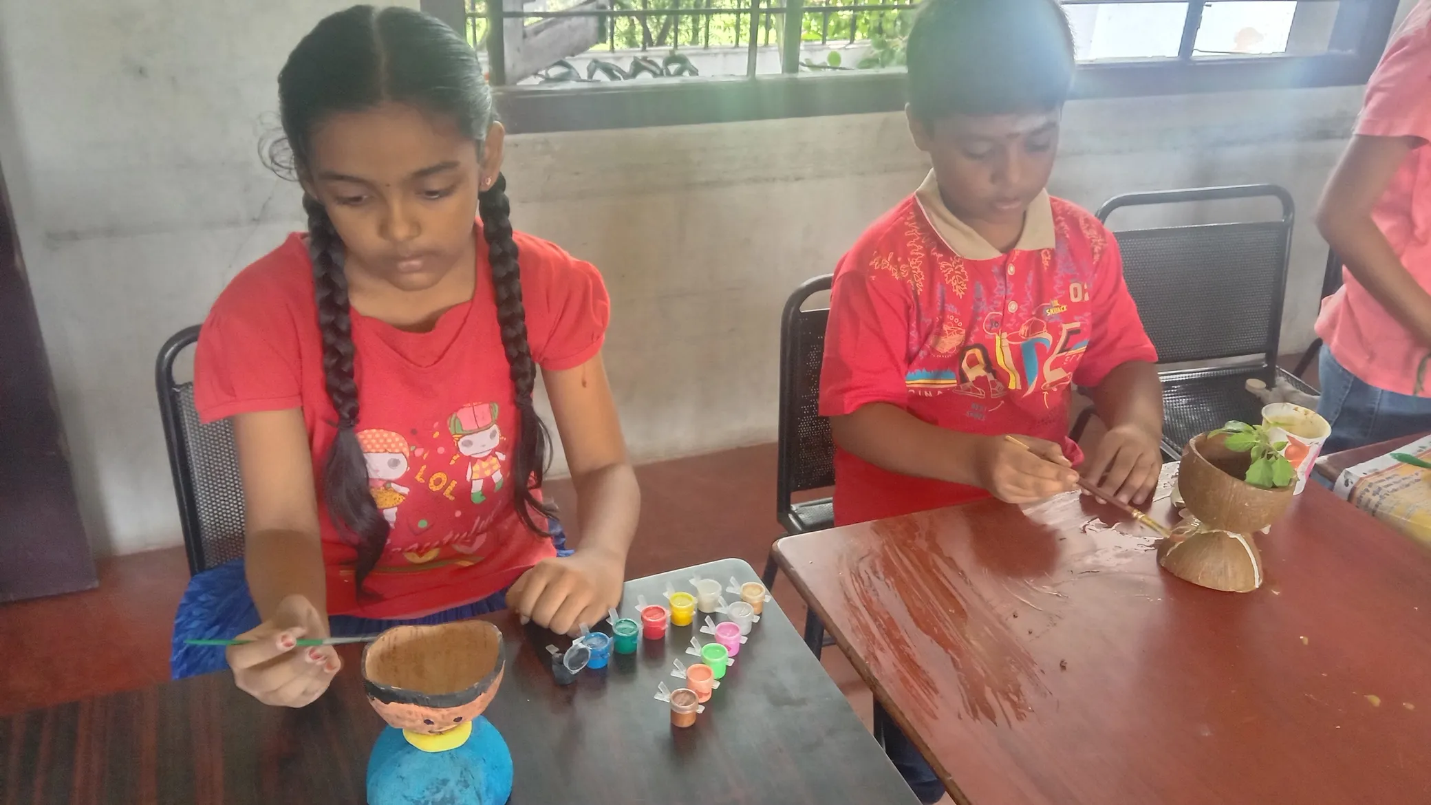 Kids at Vidhya Peetham i-School crafting unique art pieces from coconut shells.