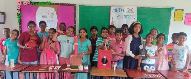 The entire Grade 5 class proudly displaying their handmade musical instruments at Vidhya Peetham i-School.