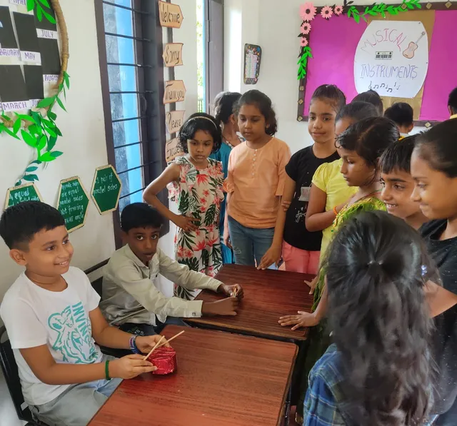 Students eagerly waiting in line to showcase their handmade musical instruments made from eco-friendly materials.