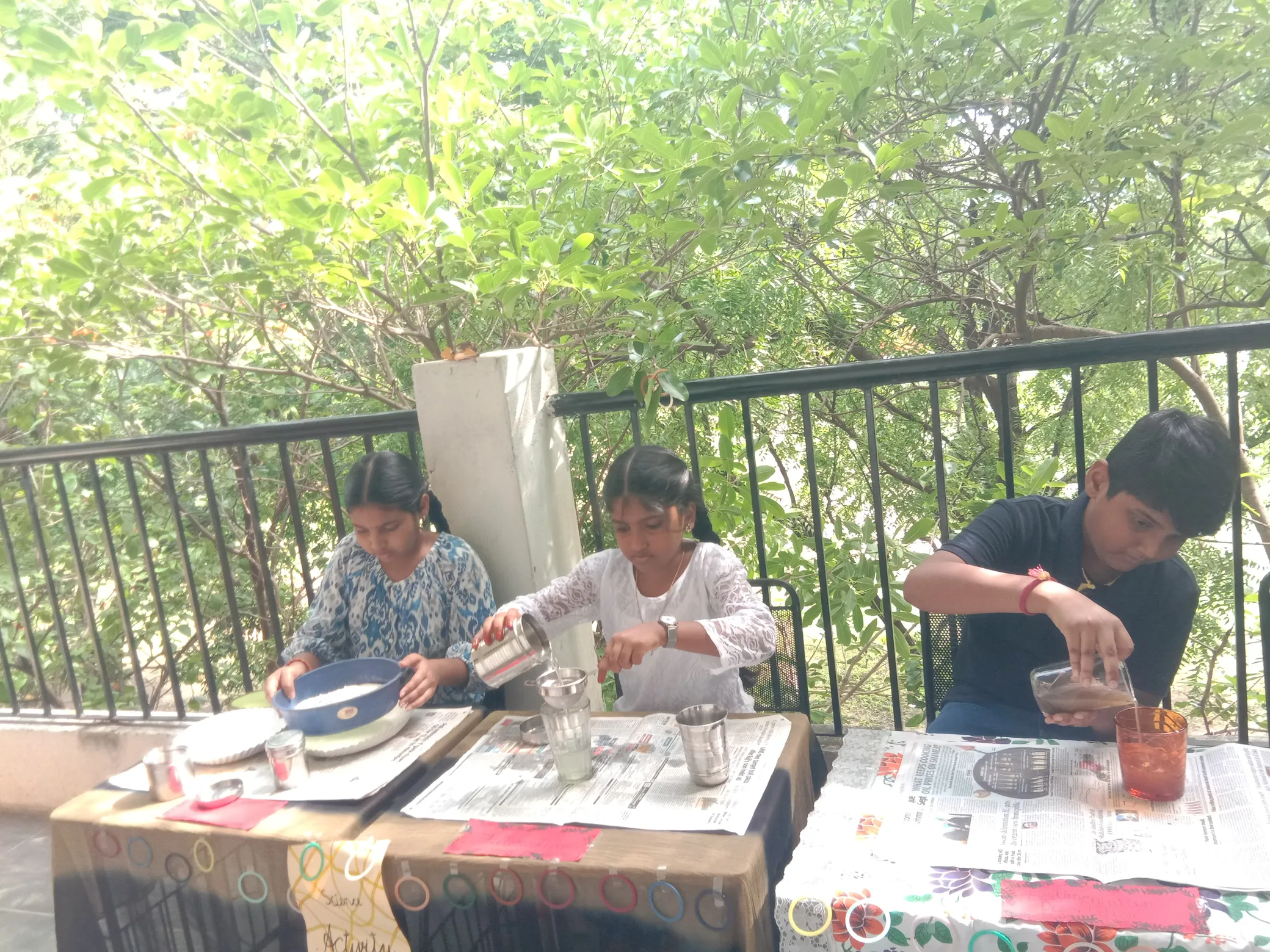 Separating substances - A team of students happily sieving flour.