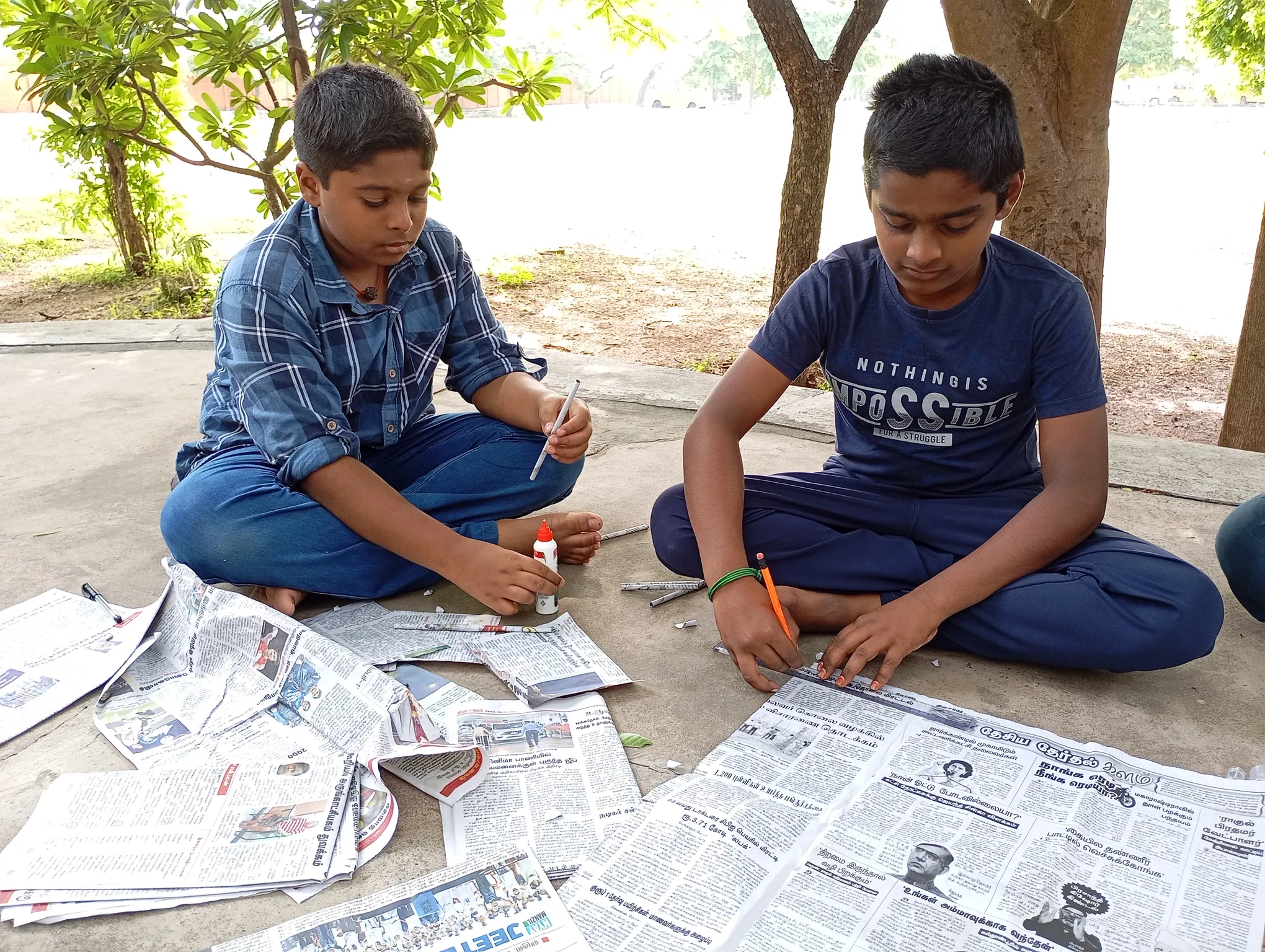 Two students creating crafts with rolled newspapers at a CBSE school in Salem.