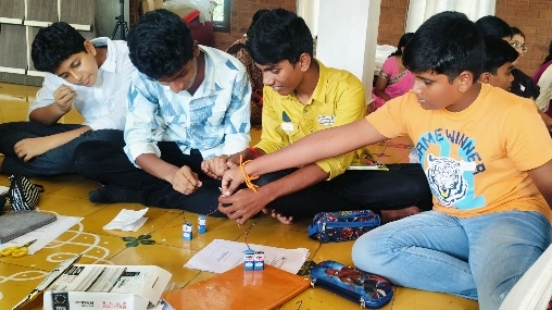 Group of boys experimenting with LEDs and connecting wires in the electronics workshop at a Salem CBSE school.