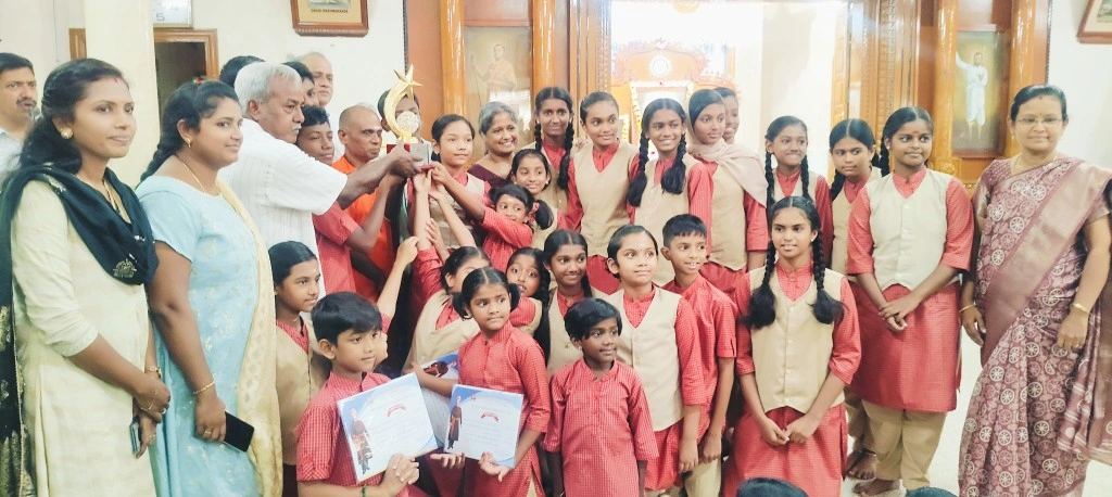 Vidhya Peetham students receive the trophy from the chief guest at the National Youth Day Competition