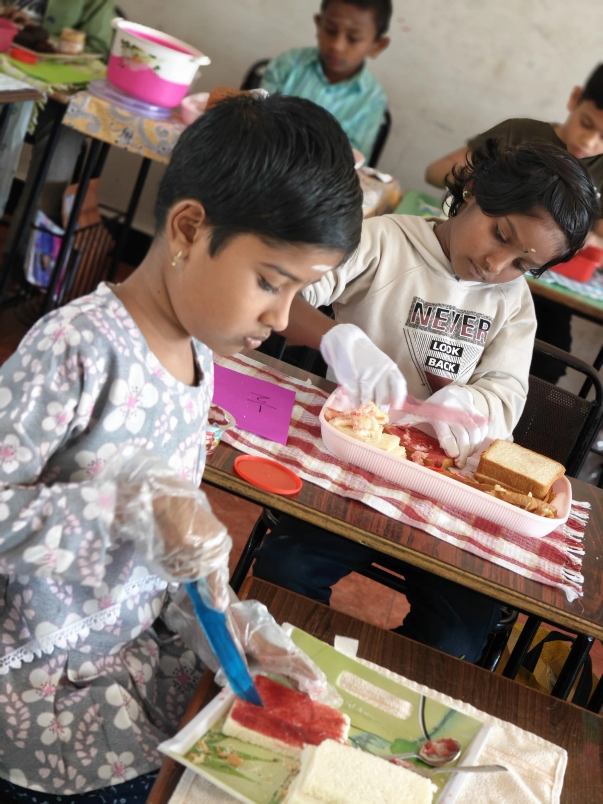 Students carefully dividing bread and applying spreads during fractions in real life activity