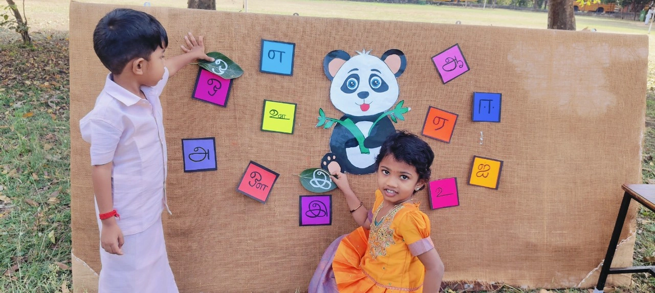 Young learners exploring Tamil உயிர் எழுத்துகள் through outdoor educational activity