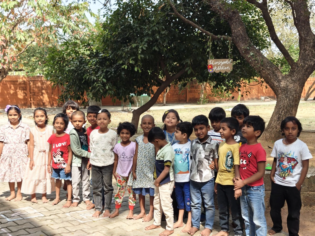 Children practicing hopscotch while learning addition in outdoor mathematics session