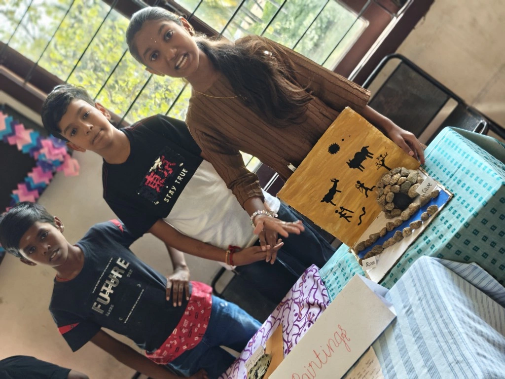 Students presenting cave art and prehistoric artifacts at history exhibition