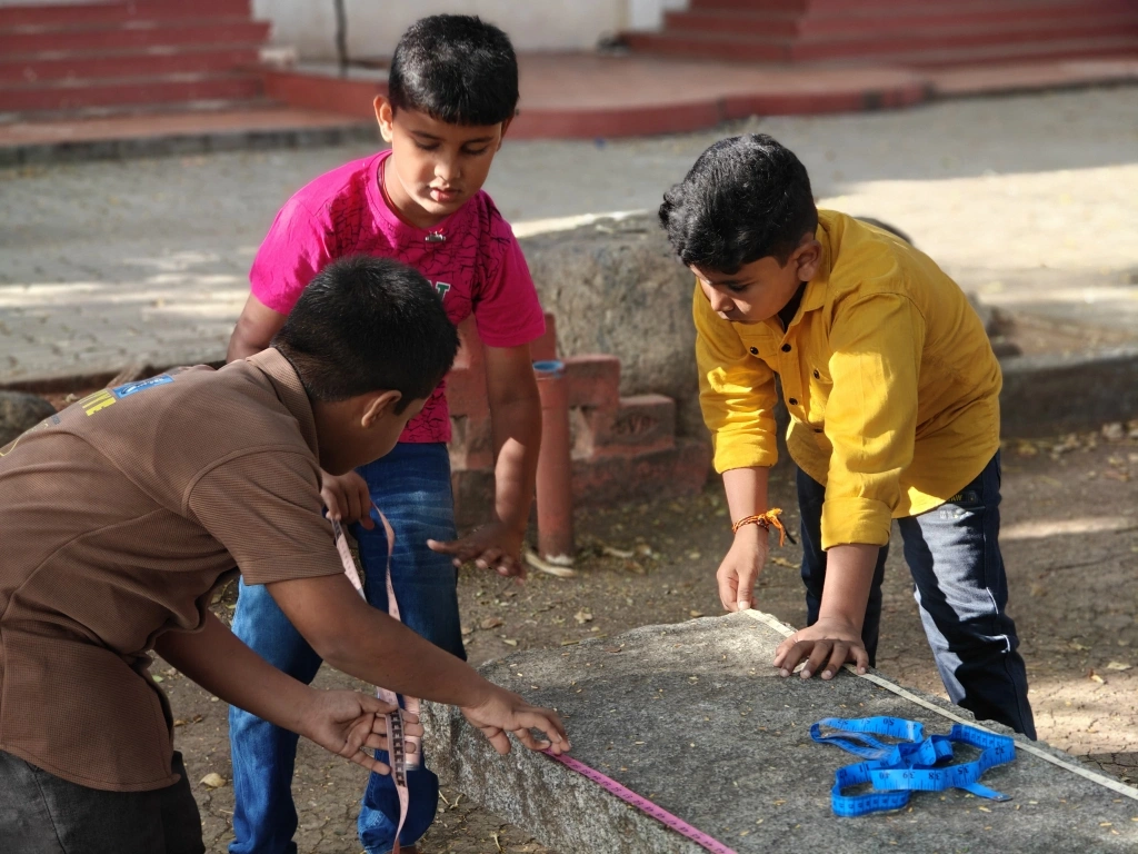 Team of students recording measurements of stone bench