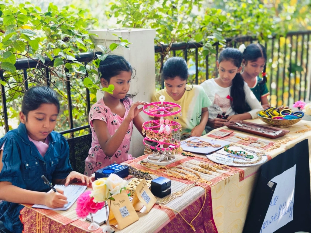 Students managing jewelry and accessories stall with creative displays